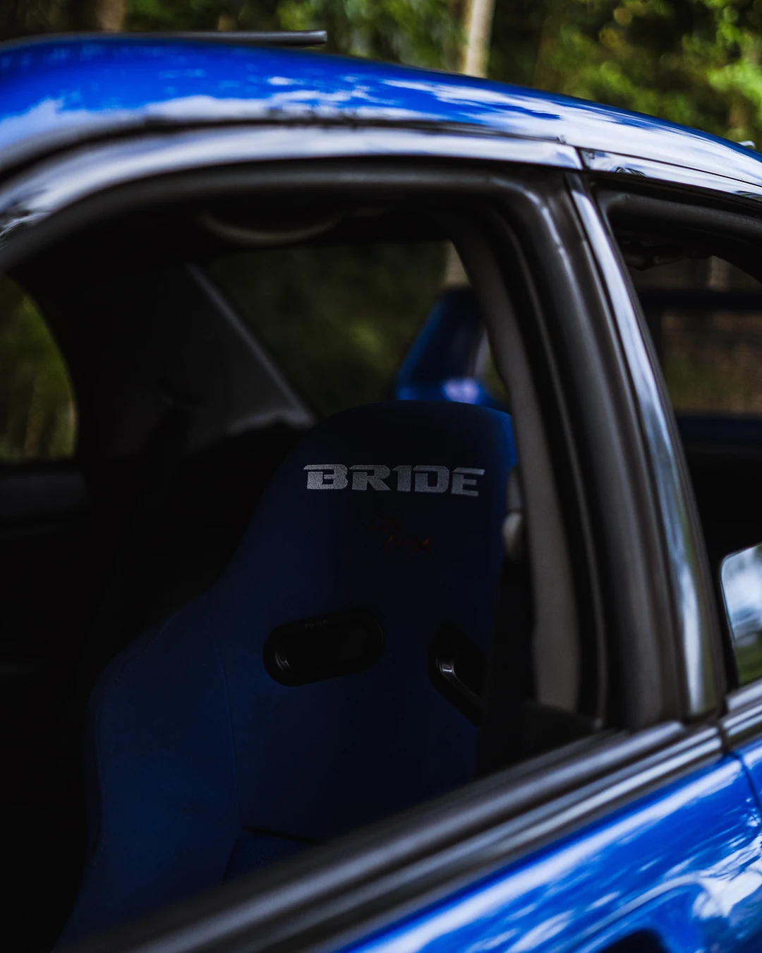 Blue Bride bucket seat seen through the open door of a blue Subaru