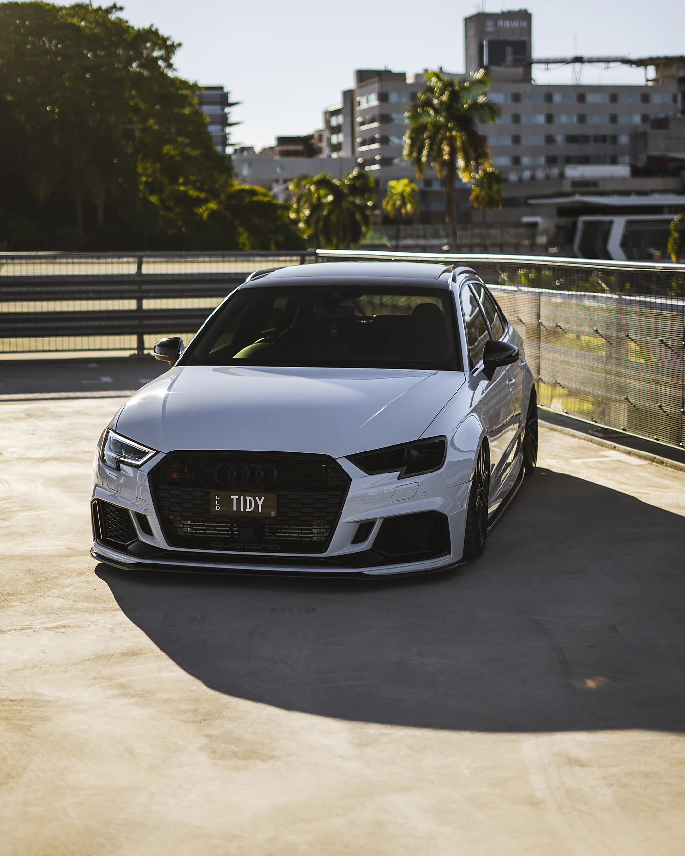 White Audi RS3 parked on a city rooftop